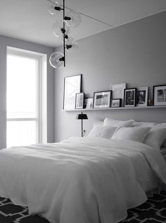a minimalist bedroom can accomodate a gallery wall on a ledge to give it a sleek look