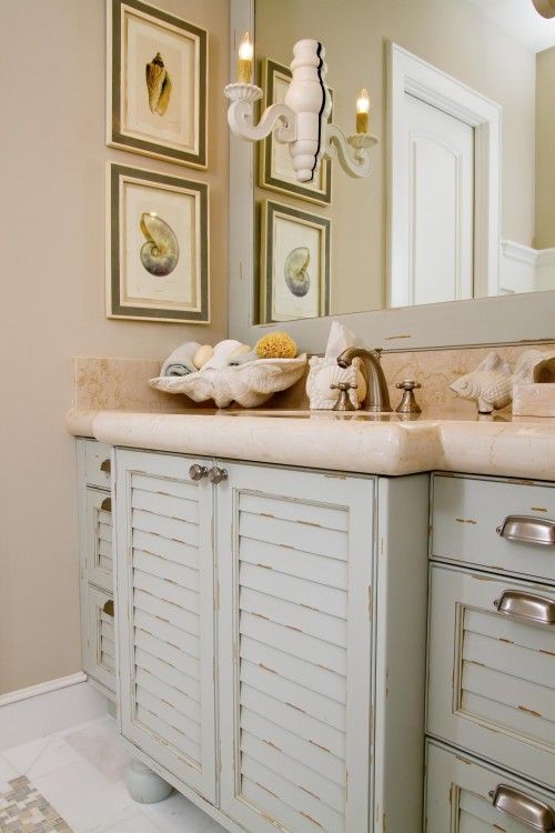 a sink vanity made of old pastel-colored shutters and a stone countertop for a beach-inspired bathroom
