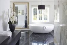 15 an oversized framed wall mirror adds more glam and chic to this marble bathroom