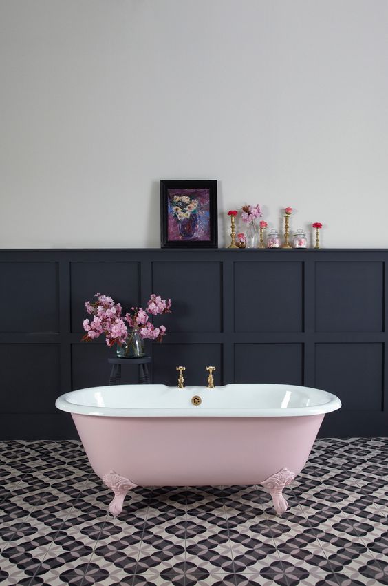 black wainscoting here creates a dramatic feel and a pink bathtub softens it