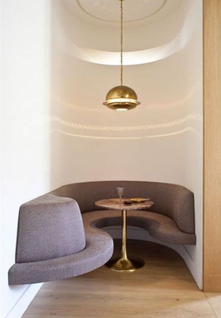 a very tiny breakfast nook with a sculptural built-in bench and a small table accomodates at least two people