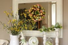 17 an Easter console with faux blooming branches, a colorful egg wreath, colorful eggs in a jar