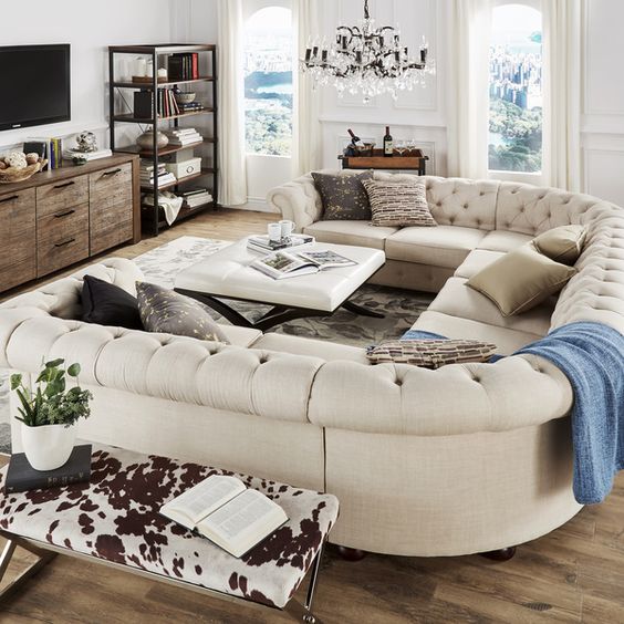 an elegant space with a rustic feel and a gorgeous U-shaped tufted sofa of creamy color that makes it more refined