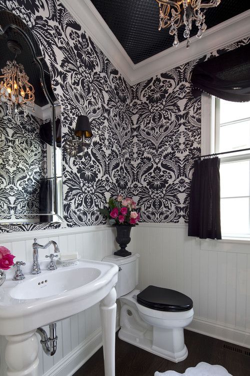 black and white printed wallpaper contrasts white wainscoting creating drama