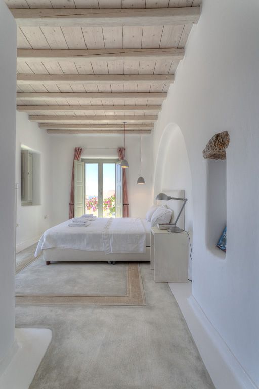 a whitewashed ceiling adds warmth to the plaster covered coastal-inspired space