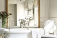 20 an oversized mirror in a vintage frame makes the bathroom exquisite, and a crystal chandelier adds to the space
