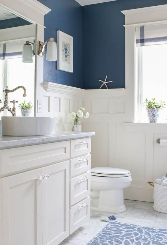 white wainscoting matches the furniture and appliances and creates a fresh feel with blue walls