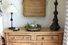 21 a rustic wooden console with a basket with greenery and a bunny, a basket with blooming branches in it