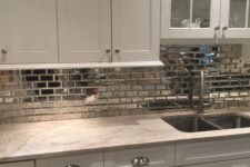 21 a silver tile backsplash makes this pearly colored kitchen shine on