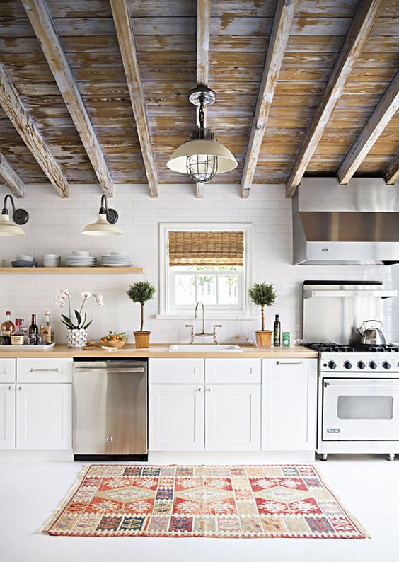 reclaimed weathered wooden ceiling with beams brings texture and interest to the usual kitchen