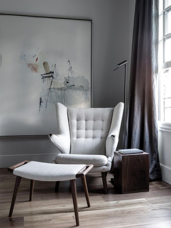 a modern take on a wingback with eye-catchy armrests and a matching foot stool