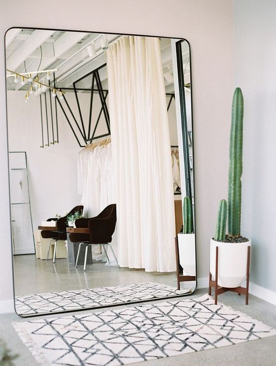 a mid-century modern entryway, where the main feature is an oversized mirror that takes a whole wall
