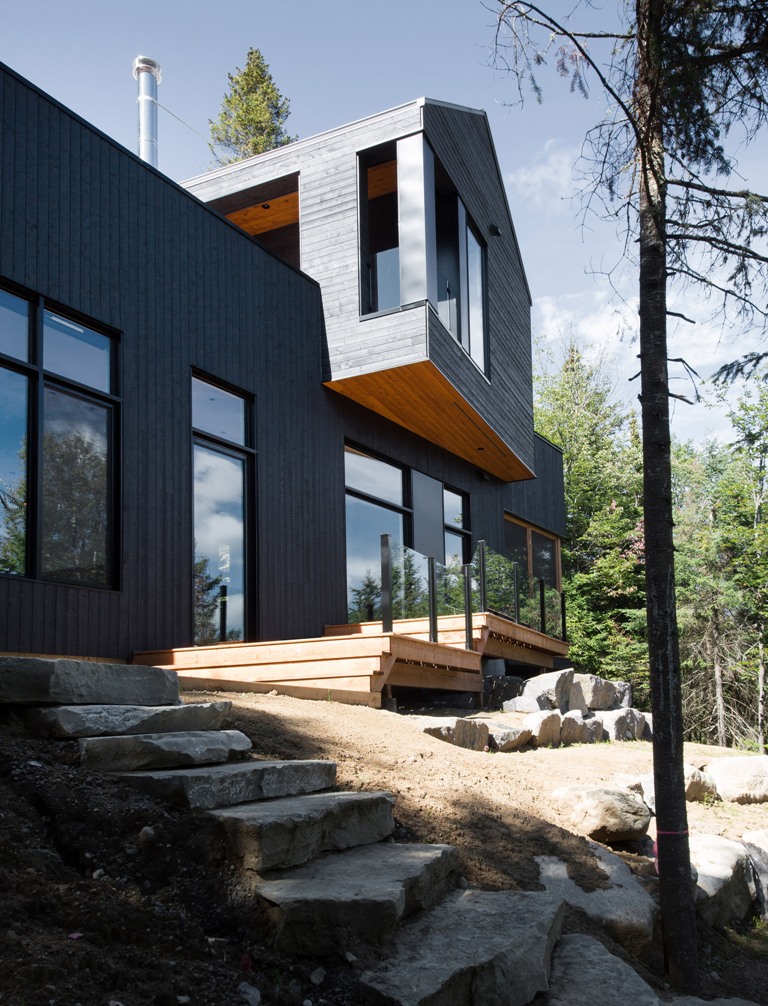 The house is located on a slope, which offers the views, and it's clad with black timber to make it blend with the surroundings The house is located on a slope, which offers the views, and it's clad with black timber to make it blend with the surroundings