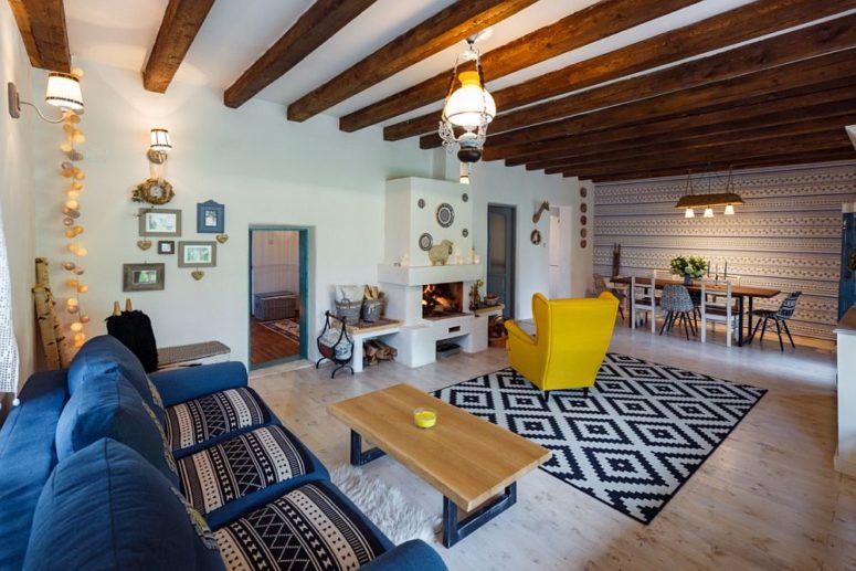 living room with exposed wooden beams The living room and dining space are united into one layout, with wooden beams and colorful furniture
