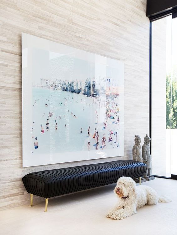 https://www.digsdigs.com/photos/2018/04/02-a-black-leather-bench-on-gilded-legs-and-an-oversized-photo-wall-art-that-feels-like-beach-holidays.jpg