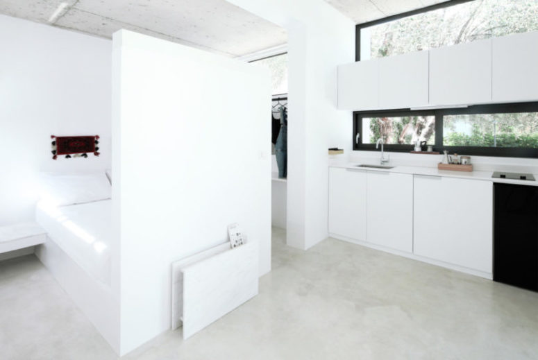 A part wall hides a bed, which also has floating nightstands on its sides