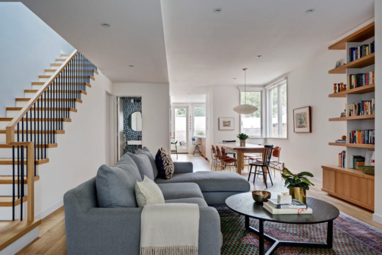 The living room and dining space are united into one layout, the living room features a large grey corner sofa The living room and dining space are united into one layout, the living room features a large grey corner sofa