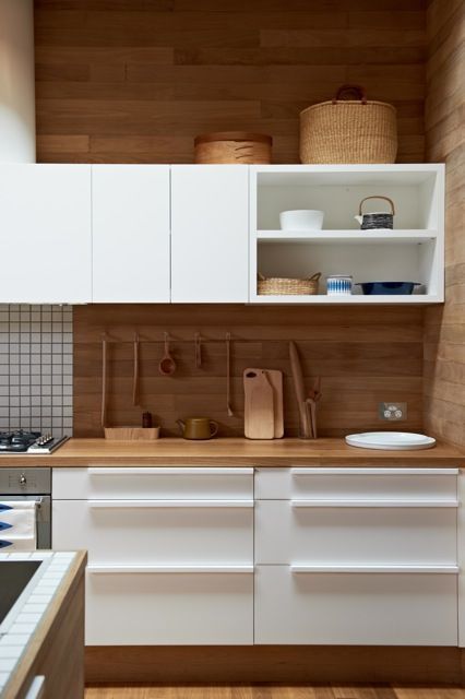 a bold contemporary kitchen with white cabinets and touches of light-colored wood for a natural feel