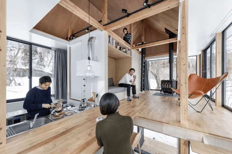The kitchen table comes into a floor in the living space with a sofa, a shelf and a hearth for warmth