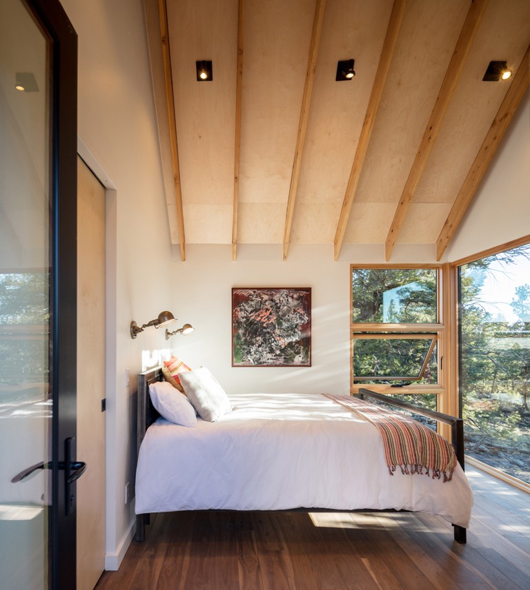 One of the bedrooms features only a large bed and two sconces as the main attraction here is the views