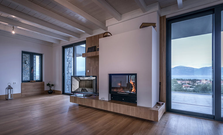 The living room is done with much light colored plywood and off whites and whte, there's a cool built in fireplace The living room is done with much light-colored plywood and off-whites and whte, there's a cool built-in fireplace