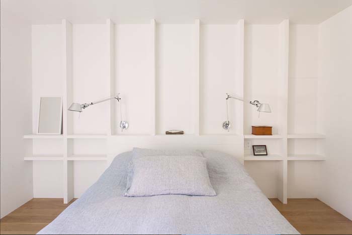 white walls for bedrooms The master bedroom features white walls with shelves, a comfy bed and some sconces