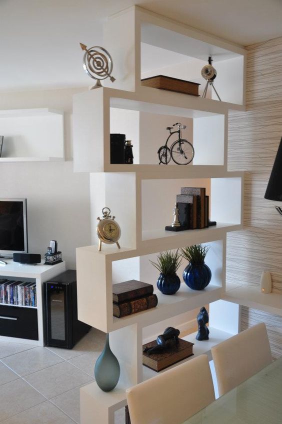 a small shelving unit going up to separate the dining and living spaces in a small studio apartment