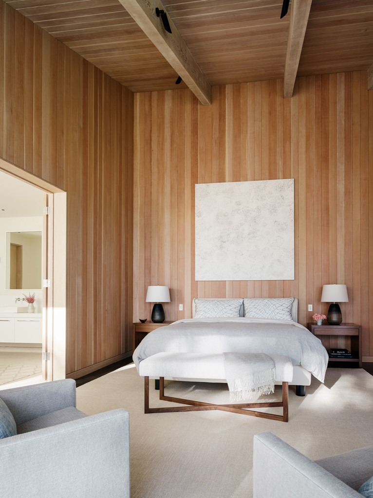 stylish and warm bedroom design The master bedroom features comfortable contemporary furniture and much wood that clads the walls and a high ceiling