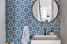 08 The powder room shows off a statement wall with gorgeous blue printed tiles and a round mirror