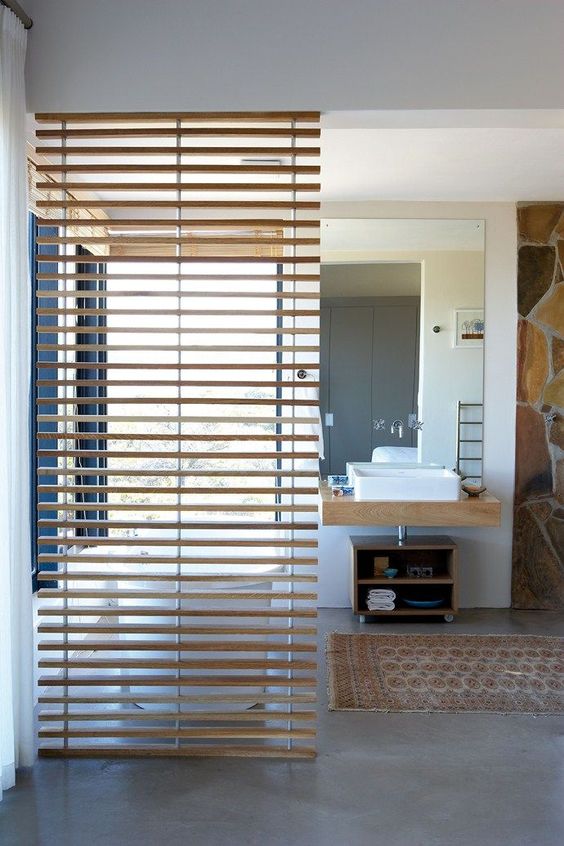 a gentle wooden screen separates a bathroom into zones for more privacy and comfort
