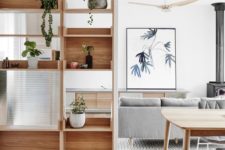 08 a modern wooden shelving unit features open and box-shaped shelves with much potted greenery for separating from the dining room