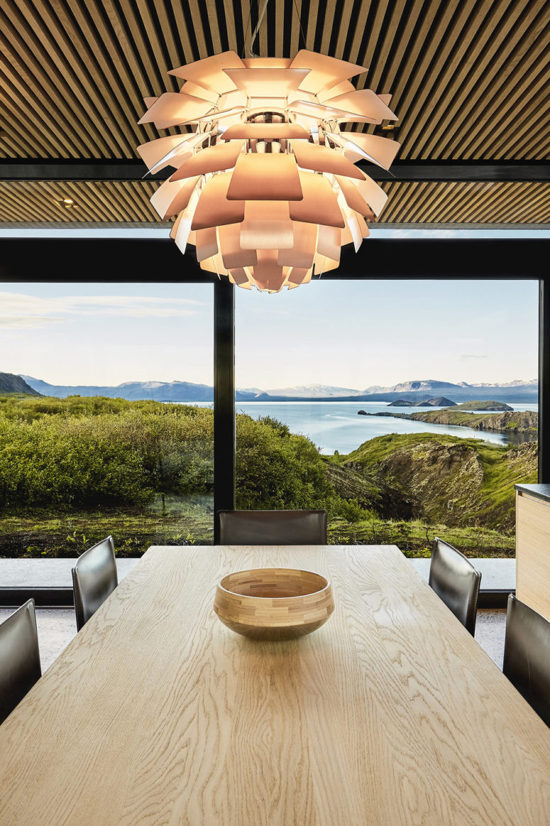 The dining space is done with black leather chairs and a light colored wooden table and look at those views The dining space is done with black leather chairs and a light-colored wooden table and look at those views