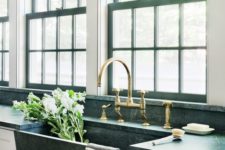 09 a dark stone sink and a green marble countertop with brass fixtures makes a bold and stylish statement
