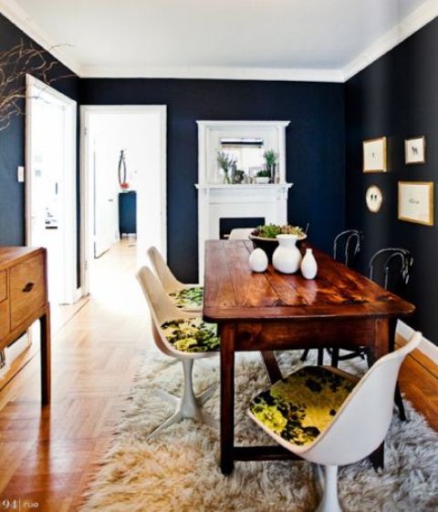 a vintage rustic dining table with modern white chairs and bold printed upholstery for a contrast