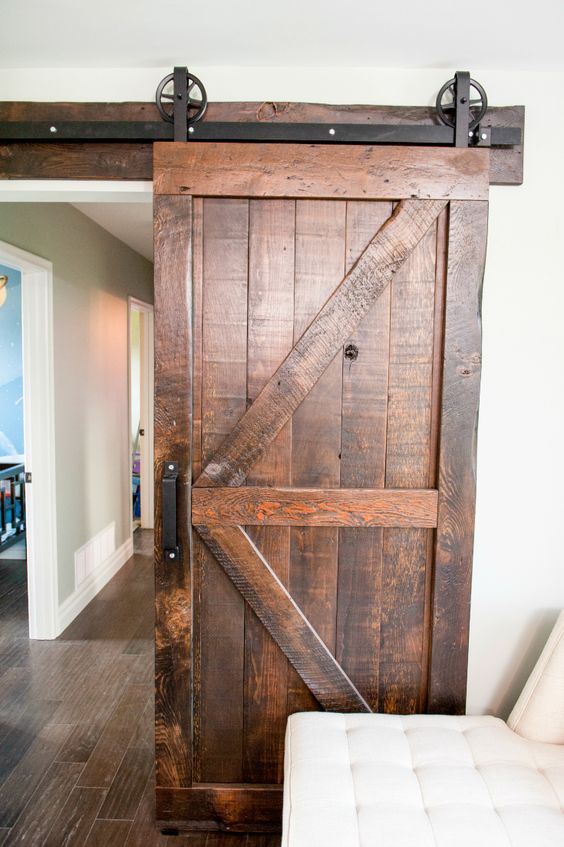 Isabella and David's sitting room is a cozy, adult space where they can relax together while the kids play elsewhere. The barn door adds a beautiful rustic element that warms the space and the printed rug keeps with the country theme. As seen on Property Brothers.