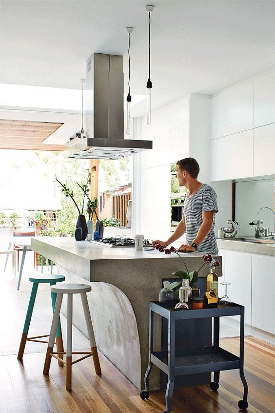 bring an industrial feel to your modern space with a concrete kitchen island and a metal hood