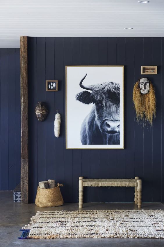 a cool navy entryway with wabi-sabi touches and a bull artwork that makes a statement