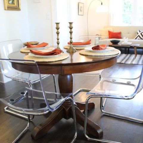 a vintage rustic round table plus clear acrylic chairs for a cozy and eye catchy breakfast zone