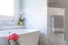 blue painted walls and grey marble tiles around the bathtub create a very peaceful look