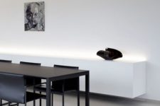 11 an ultra-minimalist space with a black dining set and a white floatign credenza with built-in lights