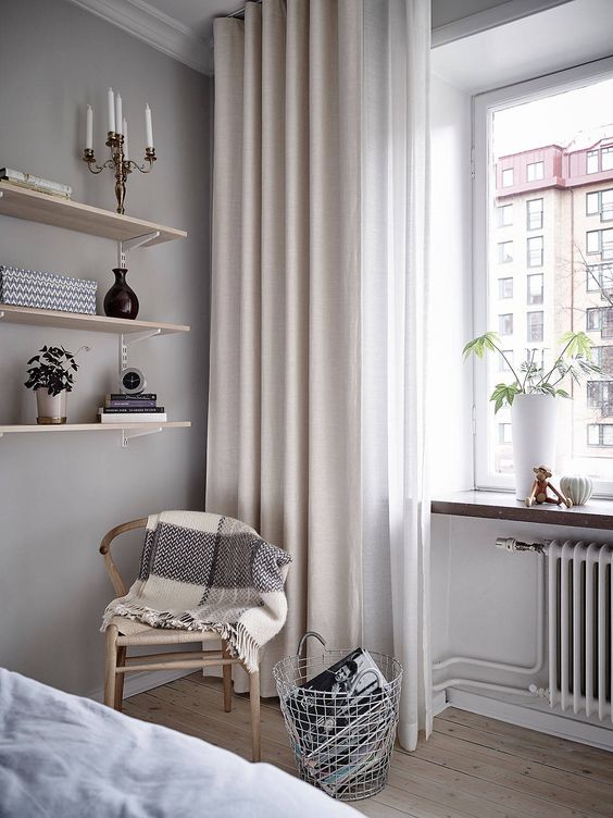 Neutral curtains hanging a bit over the floor for a lightweight and airy look in the room