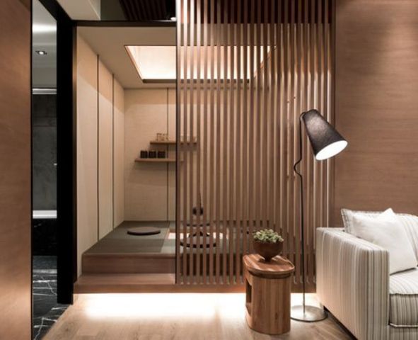 a meditation space separates from the living room with a wooden plank screen brings Asian aesthetics