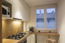12 a tiny minimalist kitchen with a wood panel backsplash and countertop, the backsplash is additionally covered with glass