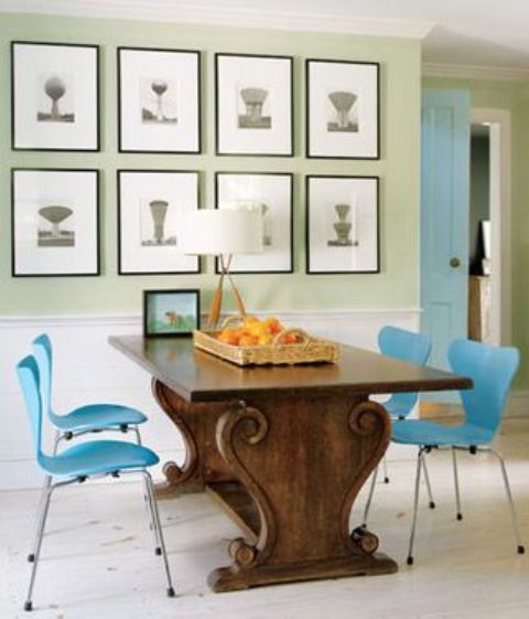 an antique table with carved legs and bold blue chairs on metal legs that highlight it