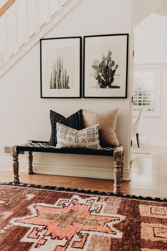 a boho bench with a woven seat and vintage legs and a duo of cacti artworks for a free-spirited look