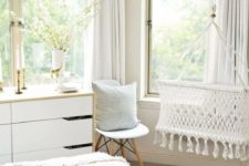 14 a peaceful light-colored space with boho touches and a woven crib hanging by the window looks heavenly
