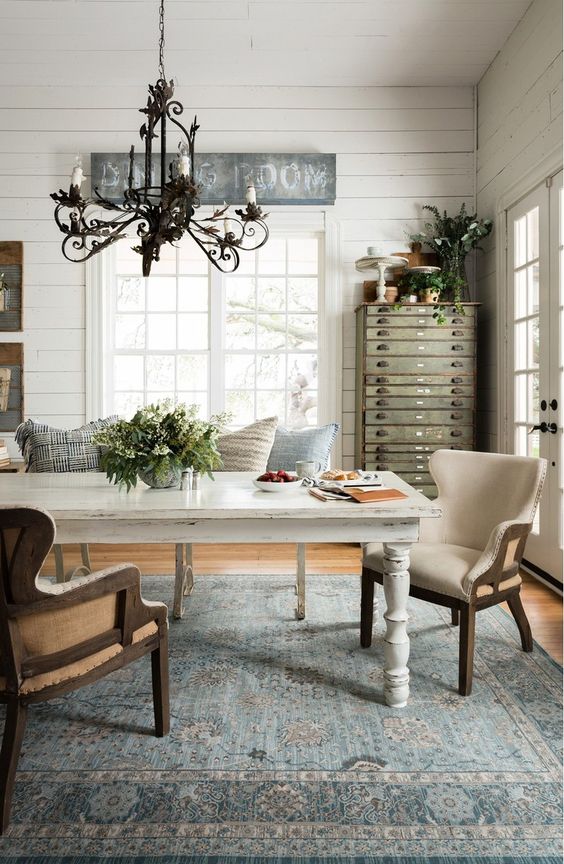 a whitewashed dining table and comfy creamy upholstered armchairs that don't look too contrasting