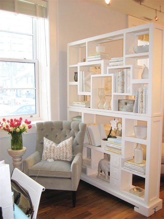a little girlish home office nook is separated from the rest of the space with an elegant white shelving unit