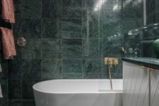 18 green marble tiles covering the whole bathroom make it a refined and a bit moody space