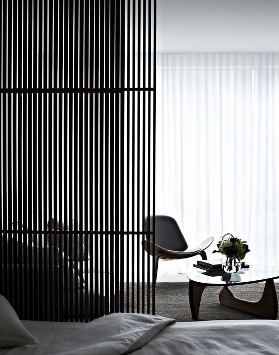 a sleek Japanese-style wooden screen separates the living space and the sleeping zone and fits minimalist decor